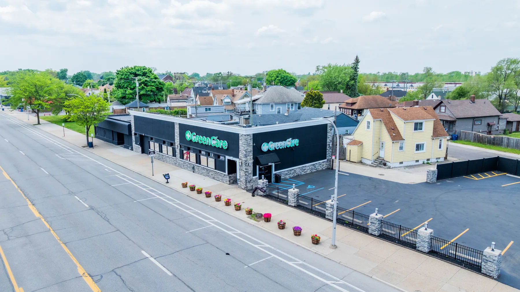 Wide aerial view of the GreenCare dispensary building and surrounding Downriver neighborhood.